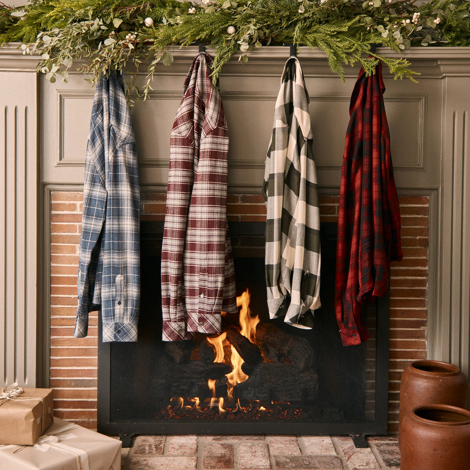 EDITORIAL IMAGE OF MULTIPLE PLAID SHIRTS HANGING ON A FIREPLACE